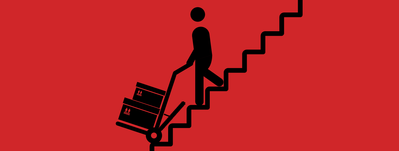 Silhouette of a person using a motorized hand truck to lift items up the stairs